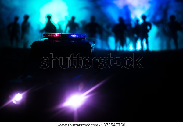 Police cars at night. Police car\
chasing a car at night with fog background. 911 Emergency response\
police car speeding to scene of crime. Selective\
focus