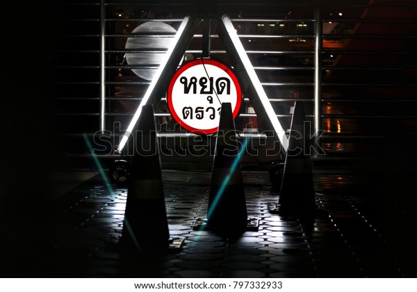 Police check point sign at nigh in\
Thai language. Stop point to check driver and rider who might over\
drink and drive, carrying drugs or drive over limit\
speed