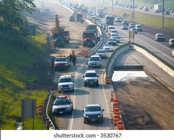 Police Clearing An Accident In A Freeway Construction Zone, With Backed-up Traffic