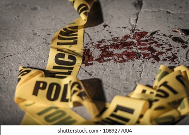 Police Cordon Tape Lies On The Ground In A Small Amount Of Blood.