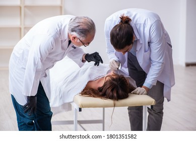 Police Coroner Examining Dead Body Corpse In Morgue