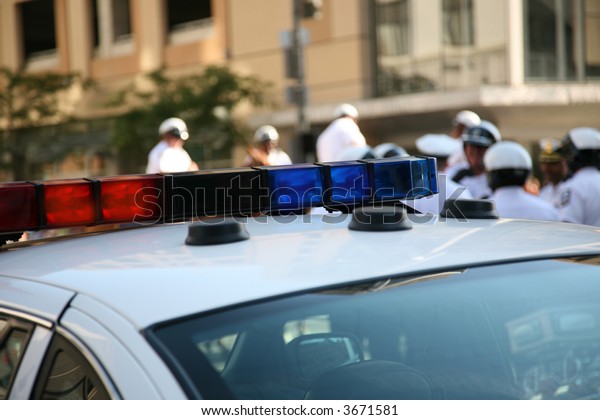 police cruiser\
with officers in the\
background