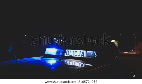 Police emergency lights flash at\
night. Car accident. Crime scene.  Flashing blue lights on patrol\
car. Police car in Poland with the lettering\
\