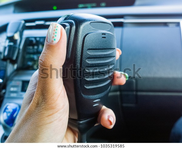 Police female\
officer using Walkie-talkie in patrol car. Two-way radio. Police\
radio. Selective focus,\
close-up.