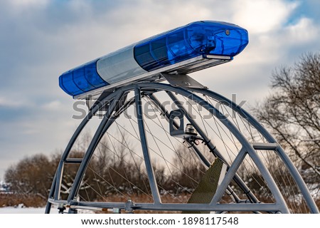 Police flashers on a snowmobile close up, police all-terrain vehicle in winter, air-cushion boat
