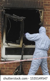 Police Forensic Officer Working At The Scene Of A House Fire. South East London, UK .