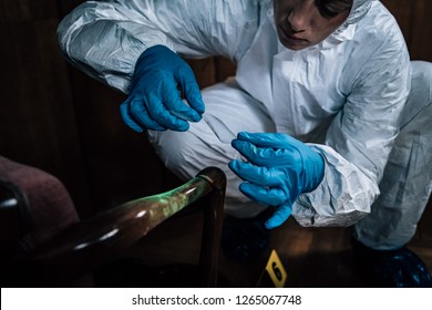 Police Forensic Science Investigator Lifting Fingerprints From A Crime Scene