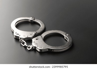 Police handcuffs on dark background with copy space