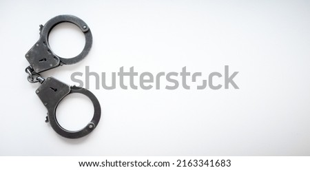 Police handcuffs on a white rectangular isolate.A clean place for the inscription. Arrest of suspects. Criminal news. Put him in jail.