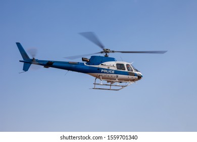 Police helicopter in flight speeding against the blue sky