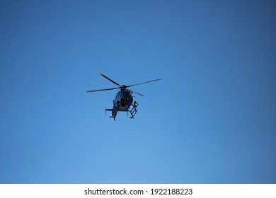 A police helicopter patrolling a city in clear sky. An airshow. Public safety concept. Stock photography.