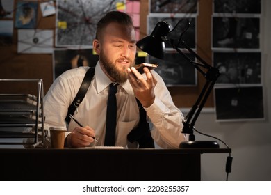 Police Investigator Working In The Office At Night, Using A Voice Assistant For Work, A Voice Recorder And A Detective's Job