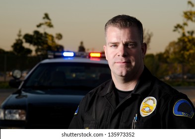 A  Police K9 Officer In Front Of His Patrol Car.