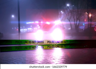 police line do not cross ribbon in front of the police car in the night