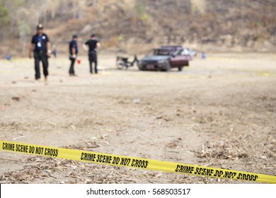 police line tape and blurred law enforcement searching wrecked car background with copy space