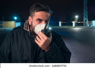 Police Man With Surgical Mask Talking With Walkie Talkie At Curfew On Streets During Alarm State In Covid 19 Coronavirus Crisis.