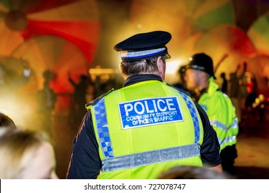 Police Officer Against A Colourful Smoke Festival Background Providing Security In The UK