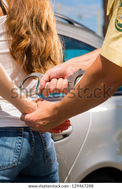 Police officer\
arresting a woman with\
handcuffs