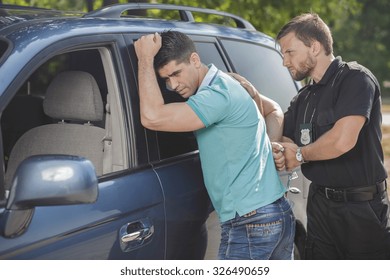 Police Officer Arresting Young Male Drunk Driver