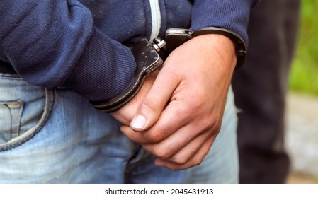 A police officer arrests a drug dealer. Weapons, handcuffs close-up.