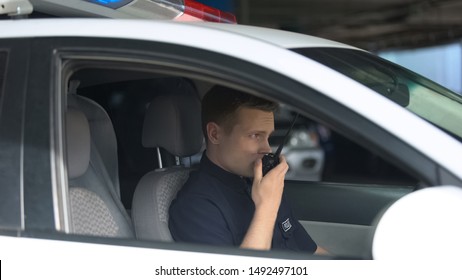 Police Officer In Car Using Walkie-talkie, Dispatcher Informing About Emergency