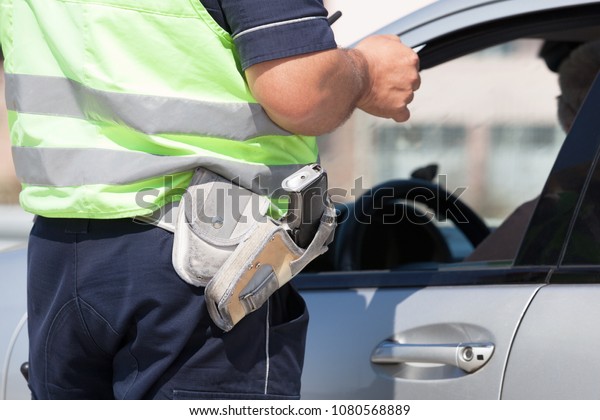 Police officer is checking the driving\
license of a car driver during a traffic\
control