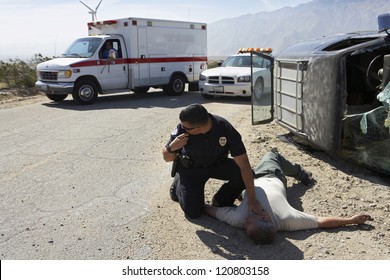 Police officer checking pulse of car crash victim - Powered by Shutterstock