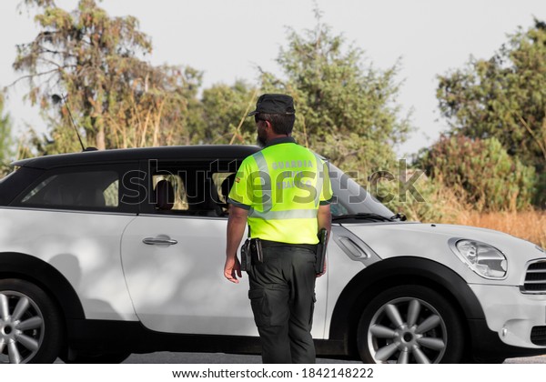A police officer\
from the Civil Traffic Guard checks a white car in Madrid, Spain.\
(Civil traffic guard)