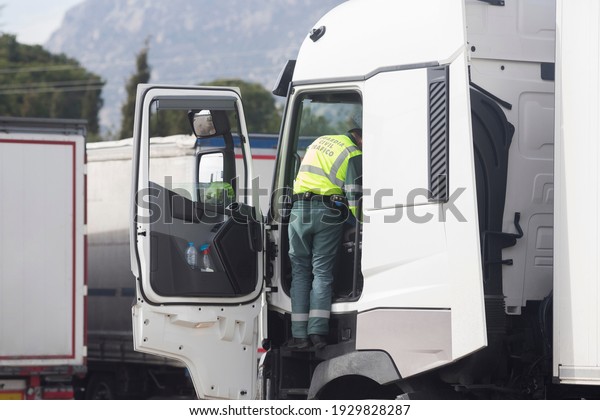 A police officer from\
the Civil Traffic Guard checks the tachometer of a white truck in\
Madrid, Spain.
