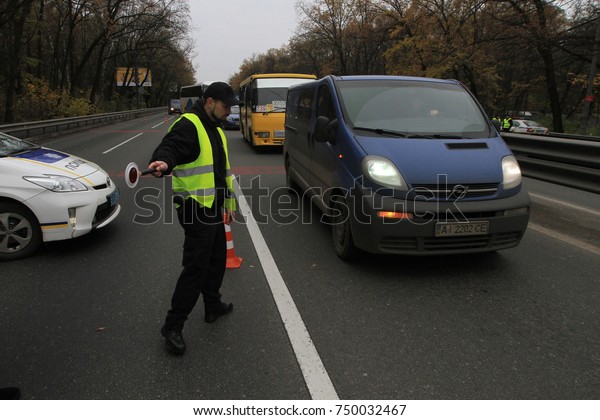 A police\
officer controls traffic on the highway near a roadblock in front\
of the city of Kiev, Ukraine,\
05.11.2017