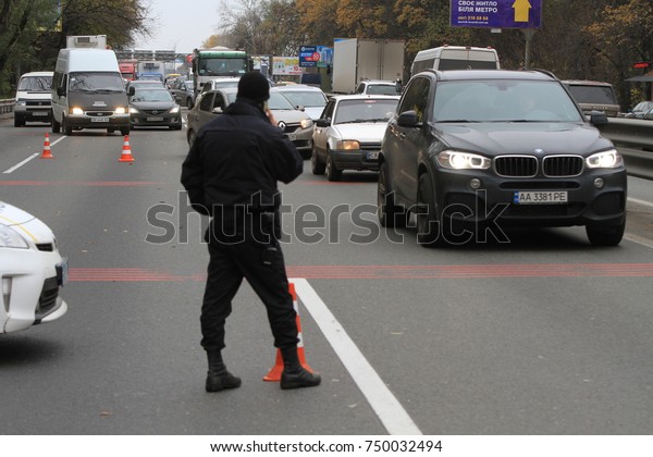 A police\
officer controls traffic on the highway near a roadblock in front\
of the city of Kiev, Ukraine,\
05.11.2017