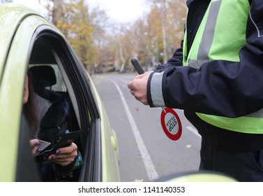 Police Officer Is Doing A Traffic Check And Looks At The Documents.