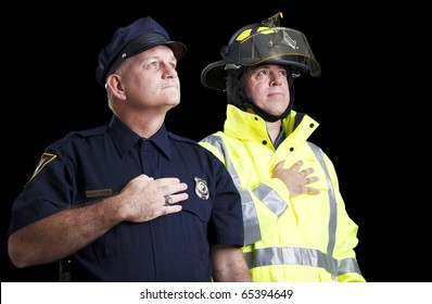 Police officer and fire fighter with their hands over their hearts as they say the Pledge of Allegiance.