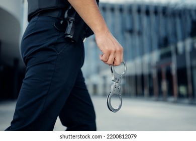 Police Officer Hand Holding Handcuffs