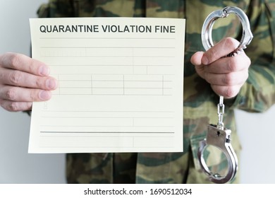 Police officer with handcuffs in khaki colored uniform stops people on the street for violating rules of quarantine of home self-isolation due to coronovirus covid-19 flu pandemic.Yellow fine receipt.