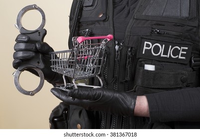 Police Officer Holding Handcuffs And Supermarket Trolley In Concept Of Shoplifting