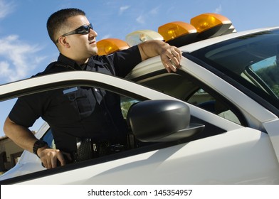 Police Officer Leaning On Patrol Car