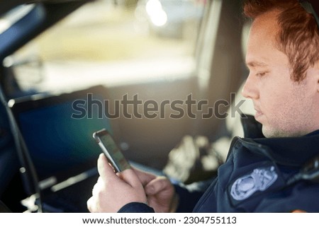 Police, officer and man texting with phone in patrol car for security contact, law enforcement update and mobile notification. Policeman typing message on cellphone for crime news, connection and app