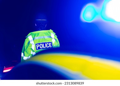 Police Officer at nighttime scene with Blue emergency lights