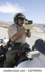 Police Officer On Motorbike Monitoring Speed Though Radar Gun