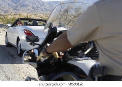 Police Officer On Motorbike Stopping Car On Desert Road Side