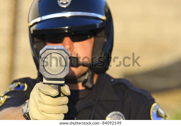 a police officer pointing his radar gun at
speeding traffic.