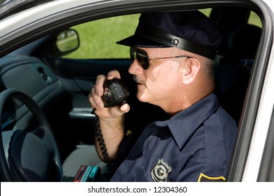 Police Officer In Squad Car Talking On His Radio.  Closeup View.