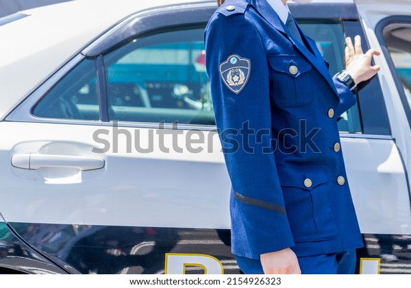 A police\
officer standing next to a police\
car.