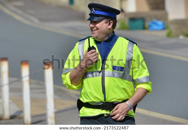 A police officer talks on a radio while standing\
guard at a roadblock after an incident in the city centre on May\
13, 2016 in Bath, UK. Emergency services responded to reports of an\
unexploded bomb.