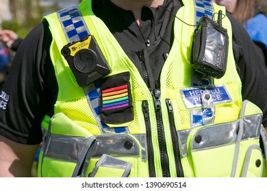 Police Officer Wearing A Rainbow Flag Symbol At A Gay Pride Parade In Support Of Diversity In The Community And Promote Good Relations.