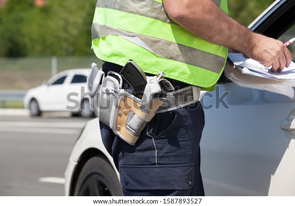 Police officer is\
writing a speeding\
ticket