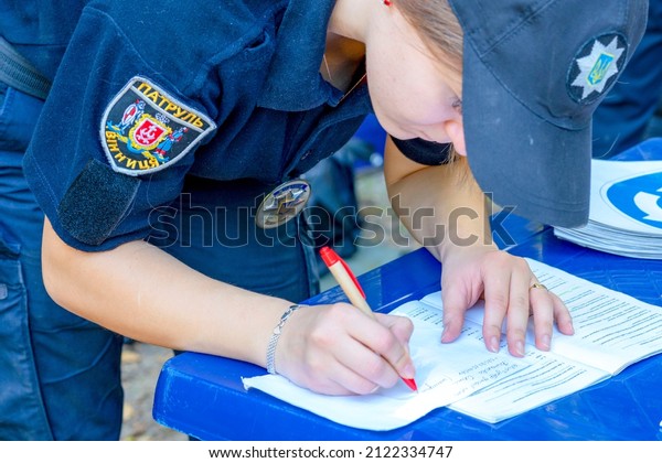 The police officer writing traffic ticket.\
The law enforcement cop, officer processes documents on offense. \
Policeman writing Penalty for violation for a driver. Vinnytsia,\
Ukraine. 22.10.2018.
