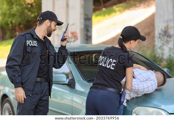 Police officers\
arresting criminal\
outdoors