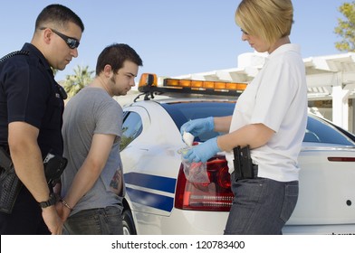 Police Officers Arresting Drog Dealer By Police Car